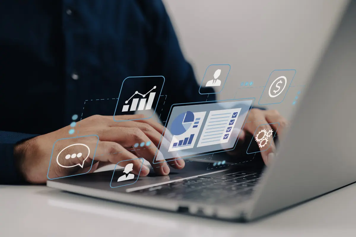 Person using laptop with digital data holograms.