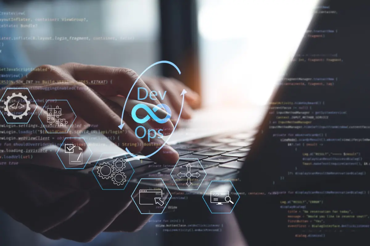 Hands typing on laptop with DevOps graphics.