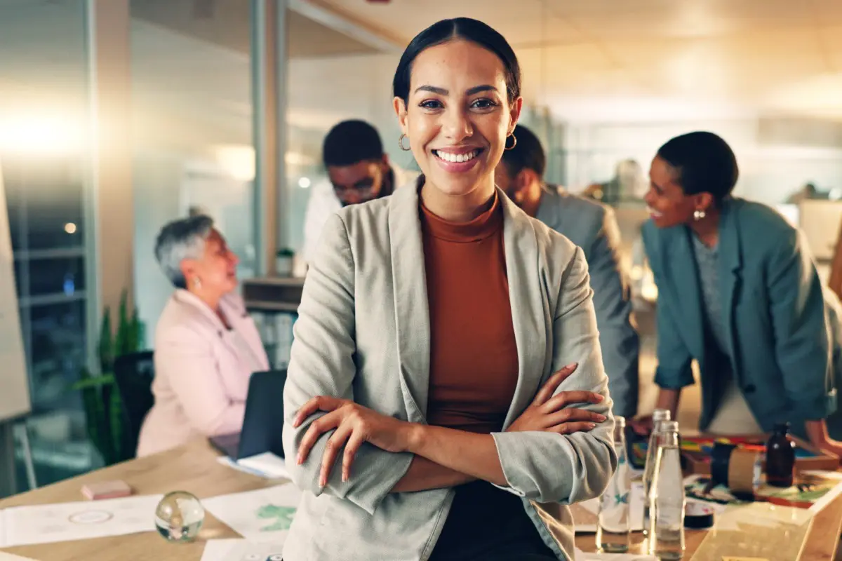 Smiling woman in office with colleagues working.