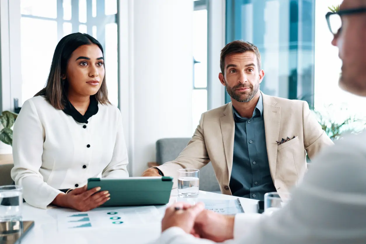 Business meeting with three people discussing.