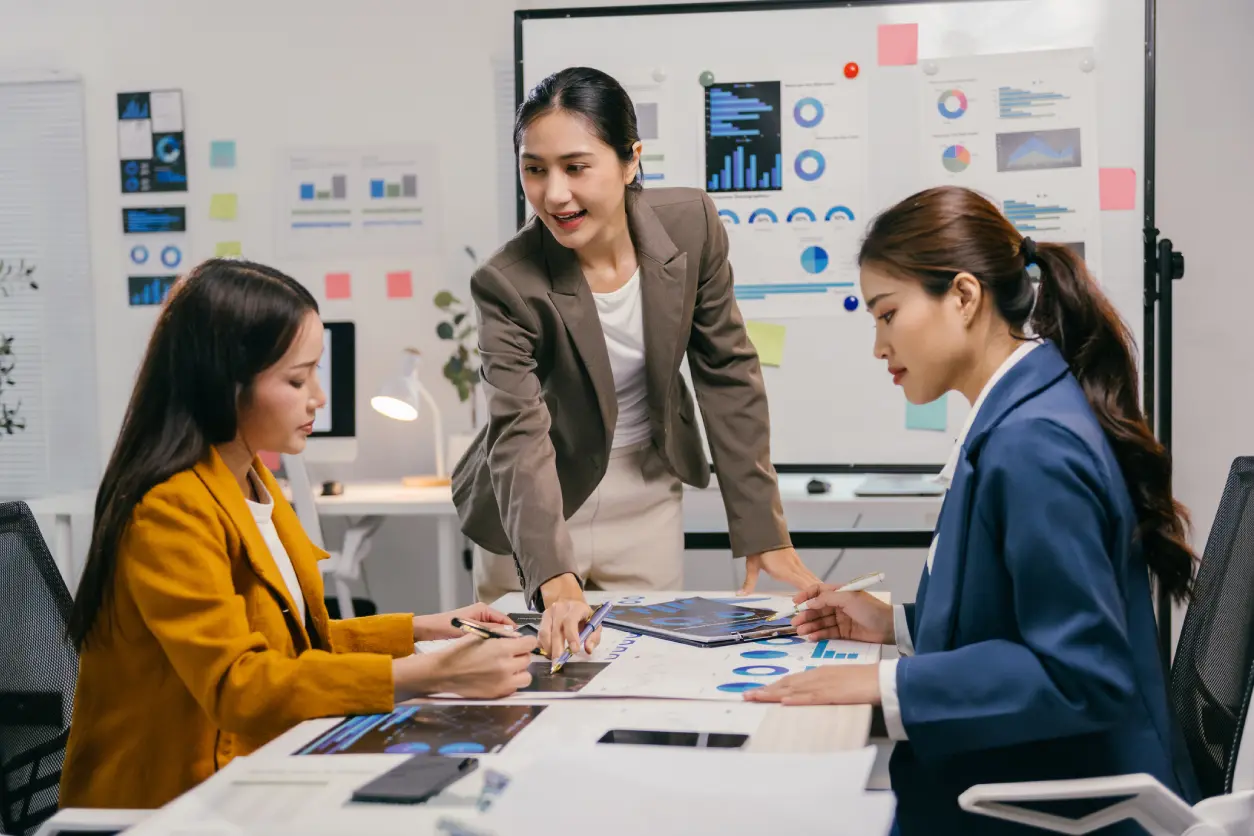 Three women collaborating in a business meeting.