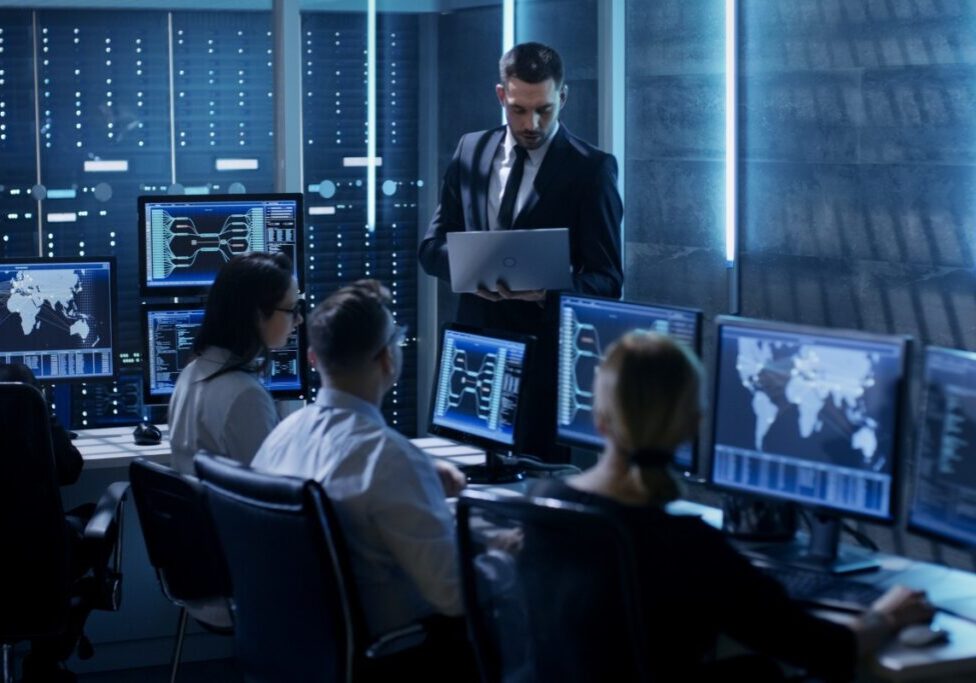Cybersecurity team monitoring multiple computer screens.